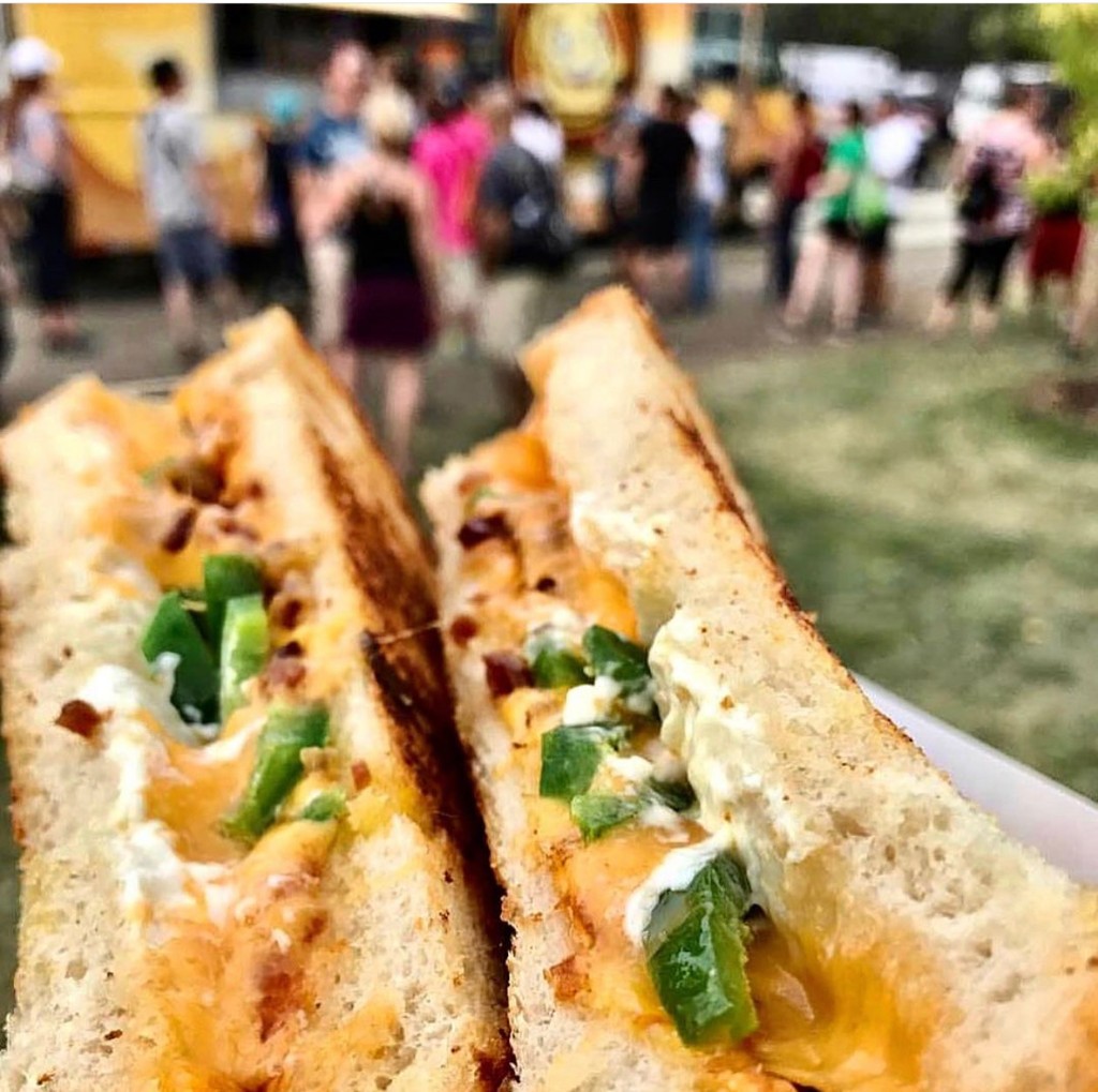 Sunny street fair with vendor tents and guests at Chicago Food Truck Festival in the South Loop