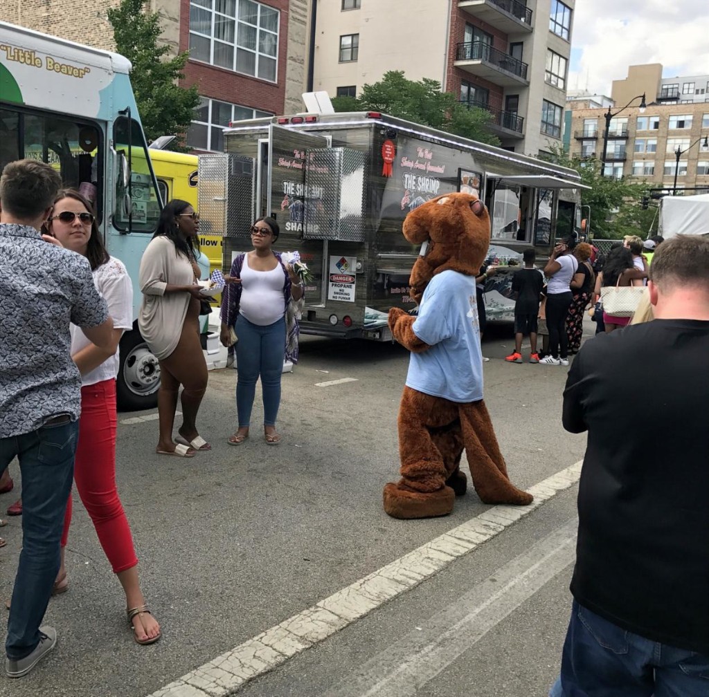 Festival midway with lobster roll tent, guests, and the downtown Chicago skyline