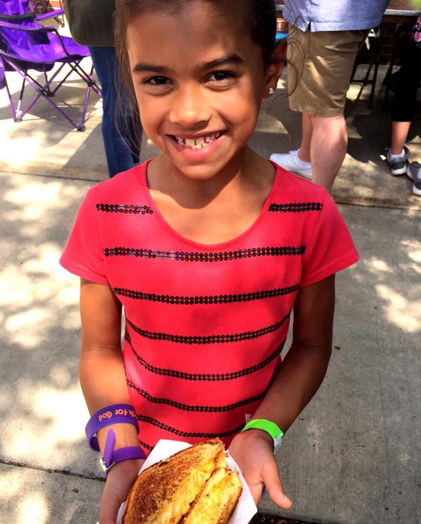Young guest with a grilled cheese sandwich at Chicago Food Truck Festival in the South Loop
